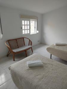 a room with a bed and a chair and a window at mar de rosa in Villanueva de Arosa