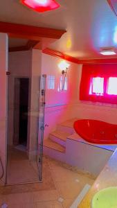 a bathroom with a shower and a red tub at Motel Avenida (Adult Only) in Gramado