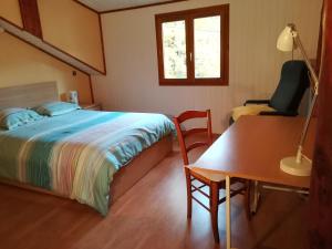 um quarto com uma cama, uma secretária e uma cadeira em Maison au calme em Viry