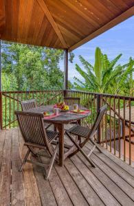 einen Tisch und Stühle auf einer Holzterrasse in der Unterkunft CHALETS TIKINOU in Saint-Pierre