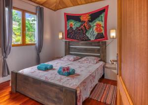 1 dormitorio con 1 cama con 2 toallas en CHALETS TIKINOU, en Saint-Pierre