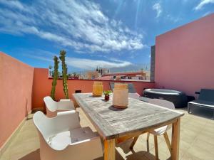 una mesa de madera y sillas en el techo en AROMAS Suites Attic, en Puerto de la Cruz