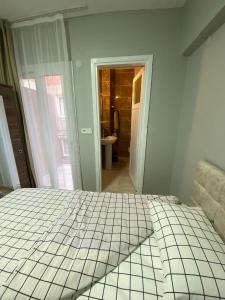 a bedroom with a white bed and a bathroom at GÜLERSU PANSIYON in Kusadası
