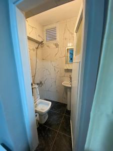 a bathroom with a white toilet and a sink at GÜLERSU PANSIYON in Kusadası