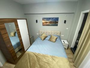 a small bedroom with a bed and a mirror at GÜLERSU PANSIYON in Kusadası