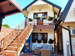 a house with a balcony with potted plants at Pensiunea Filippo in Mila Douăzeci şi Trei