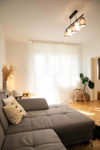 uma sala de estar com um sofá em frente a uma janela em Firpo Apartman em Eger
