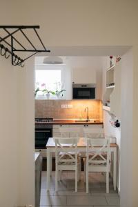 uma cozinha com uma mesa e cadeiras e um lavatório em Firpo Apartman em Eger