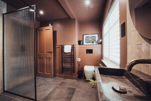 a bathroom with a shower and a toilet at The Silk Rooms, at The Freemasons Inn in Knutsford