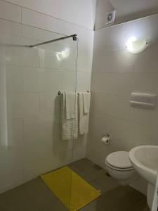 a white bathroom with a toilet and a sink at Apt71 Porto Antigo 2 in Santa Maria