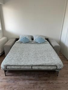 1 cama con 2 almohadas azules en una habitación en Joli studio les pieds dans l'eau, en Fréjus