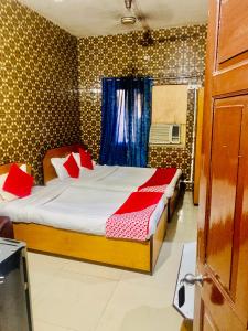 a bedroom with a bed with red pillows at Hotel Bengal in Kolkata