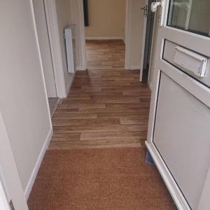 a hallway with wooden floors in a room with a door at Stylish 2 bed flat at Camber Sands in Camber