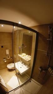 a bathroom with a shower and a sink and a toilet at Hotel Kimen - Annex in Cres