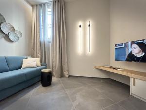 a living room with a blue couch and a tv at Casa Esmeralda in La Spezia