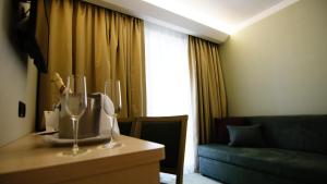 una camera d'albergo con divano e tavolo con bicchieri da vino di Hotel Kimen - Annex a Cres