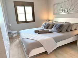 uma grande cama branca num quarto com uma janela em Minutes to the beach, near Convention Centre and free parking em Barcelona