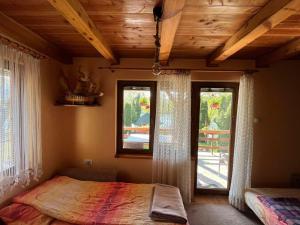 Ljubovija的住宿－Apartman "Kapetana luka"，一间卧室配有床和两个带窗帘的窗户