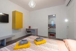 a bedroom with a bed with yellow cushions on it at Lemon's Apartment in Elmas