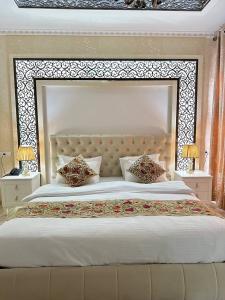 a large bed with a large headboard in a bedroom at Grand Nodirbek Boutique Hotel in Bukhara