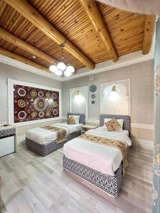 a bedroom with two beds in a room at Grand Nodirbek Boutique Hotel in Bukhara