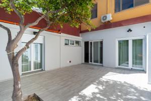 an empty courtyard of a building with a tree at Lemon's Apartment in Elmas