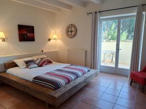 a bedroom with a bed with a clock on the wall at Hôtel restaurant Clos des Sullys in Montclus