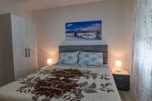 - une chambre dotée d'un lit avec une photo sur le mur dans l'établissement Apartman OLGA, à Perućac