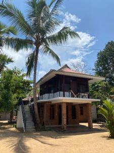 een huis met een palmboom ervoor bij Rams Resort in Arugam Bay