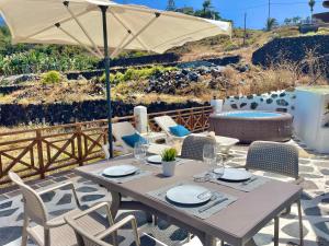 einen Tisch mit Stühlen und einem Sonnenschirm auf einer Terrasse in der Unterkunft Bollullo Paradise in La Orotava