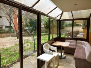ゴールデン・サンズにあるLovely nest with glass verandaのソファ、テーブル、椅子付きのポーチ