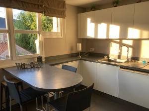 kuchnia ze stołem, krzesłami i zlewem w obiekcie Agréable et spacieuse maison centre ville Saint-Omer w mieście Saint-Omer +10 zdjęć