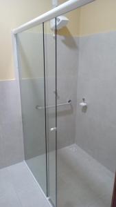 a shower with a glass door in a bathroom at Hotel do Carmo in Piracuruca
