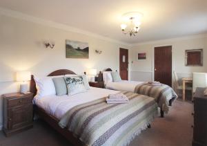 a hotel room with two beds and a table at Bridge House in Haltwhistle
