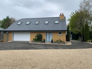 a yellow house with two white garage doors at The Mews in Newbridge