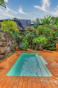 a swimming pool on a wooden deck with a garden at CHALETS TIKINOU in Saint-Pierre