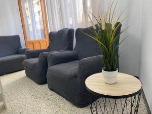 een woonkamer met een stoel en een tafel met een plant bij Alojamiento Central Caravaca in Caravaca de la Cruz