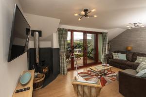 a living room with a couch and a fireplace at Hillside Balcony in Kingussie