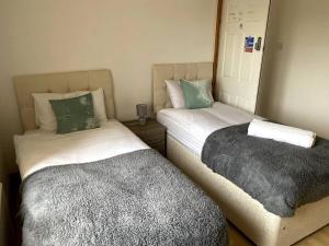two beds sitting next to each other in a room at Amazing 4 bed Contractor hub in Nuneaton +3 photos