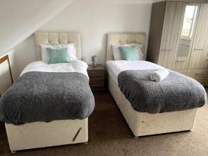 two beds sitting next to each other in a bedroom at Amazing 4 bed Contractor hub in Nuneaton