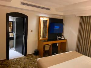 Habitación de hotel con cama y escritorio en Al Salam Royal Hotel Suites, en Taif