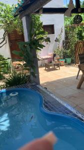 a small swimming pool in a yard with a house at Pousada da Lucinha in Canoa Quebrada