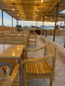 a row of tables and benches in a restaurant at Hotel Saidkasim with a Terrace in Bukhara