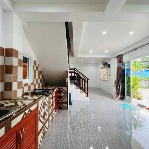 a kitchen with a counter top and a staircase at Phujhaofa villa club ( ไสยวน) in Ban Saiyuan (1)