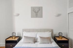 um quarto com uma cama branca com duas mesas de cabeceira em Hububb Luxury Knightsbridge House em Londres
