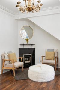 uma sala de estar com duas cadeiras e um lustre em Hububb Luxury Knightsbridge House em Londres