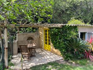 een patio met stoelen en een gele deur bij La Calanque de Figuerolles in La Ciotat