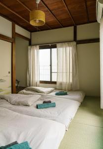 two beds in a room with a large window at Spacious 80m2 Private House, central Tokyo in Tokyo