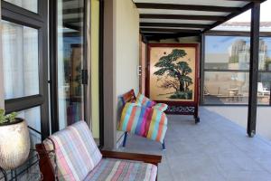 un portico con divano e sedia sul balcone di Suryia Sleeps a Città del Capo