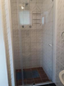 a shower with a glass door in a bathroom at Heila & Glen's Cottage in Bloemfontein